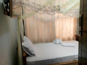 Turiani的住宿－WAWA HOTEL，一间卧室配有一张带天蓬的床