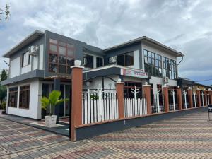 un bâtiment avec une clôture devant lui dans l'établissement WAWA HOTEL, à Turiani