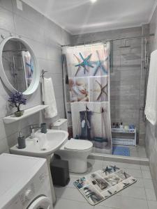 a bathroom with a sink toilet and a shower curtain at Alexandra`s House in Matala