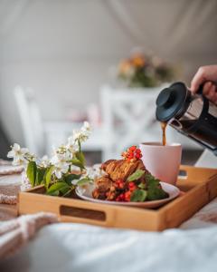 talerz jedzenia na drewnianej tacy z drinkiem w obiekcie Glamping Bobrowniczki w Kotlinie Kłodzkiej w Szczytnej