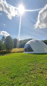 namiot na polu ze słońcem na niebie w obiekcie Glamping Bobrowniczki w Kotlinie Kłodzkiej w Szczytnej
