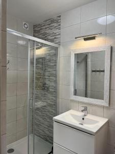 a bathroom with a shower and a sink and a mirror at Domki Słoneczka in Sarbinowo