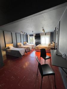 Cette chambre comprend 3 lits, une table et des chaises. dans l'établissement Luma Boutique Hotel, à San Carlos de Bariloche