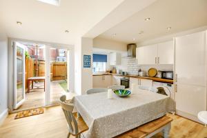 a kitchen and dining room with a table and chairs at Keeling in Exmouth