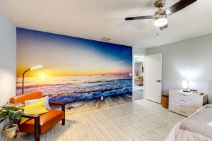 a bedroom with a painting of the beach at Port of Call in Port Charlotte