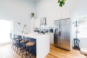 a kitchen with white cabinets and a stainless steel refrigerator at The Blue Heron Cottage in Saint Augustine