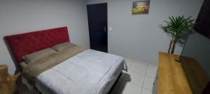 a bedroom with a bed with a red head board at Studio 53 in Blumenau
