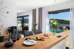 ein Esszimmer mit einem Tisch mit Speise- und Weingläsern in der Unterkunft Luxury villa Indigo with swimming pool, sauna and jacuzzi in Kanica - Rogoznica in Sevid