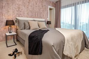 ein Schlafzimmer mit einem großen Bett mit einem großen Fenster in der Unterkunft Luxury villa Indigo with swimming pool, sauna and jacuzzi in Kanica - Rogoznica in Sevid + 38 Fotos
