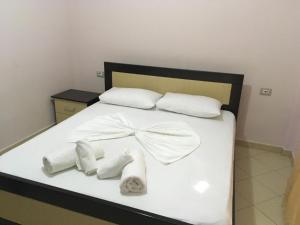 a bed with white towels and a bow on it at Zak's Apartments in Ksamil +10 photos