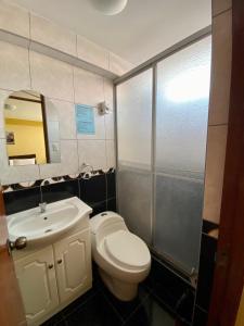 a bathroom with a toilet and a sink and a mirror at Pachamama Hostel in Cusco