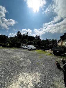 a parking lot with two cars and a white trailer at / /Sacré studio/ /wifi/ /parking privé in Rodez