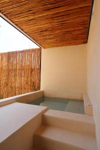 a room with stairs and a wooden ceiling at Akbal Tulum in Tulum