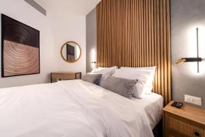 um quarto com uma grande cama branca e um espelho em Nathan's Suites On The Beach em Eilat