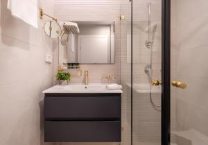 La salle de bains est pourvue d'un lavabo et d'une douche. dans l'établissement Nathan's Suites On The Beach, à Eilat