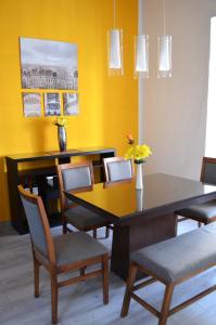 una sala da pranzo con tavolo, sedie e parete gialla di Le Chat Noir by Rotamundos a Oriental