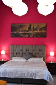 um quarto com paredes vermelhas e uma cama com 2 candeeiros em Le Chat Noir by Rotamundos em Oriental