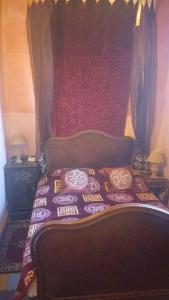 a bedroom with a bed with a red wall at La Maison Haute Larache Morocco in Larache