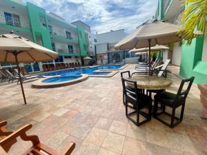 un patio al aire libre con mesas, sillas y sombrillas en Quality Inn Mazatlan en Mazatlán