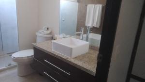een badkamer met een witte wastafel en een toilet bij Suite Lof 206 in Monterrey
