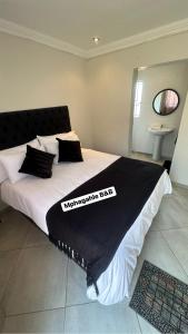 a bed with a black and white blanket on it at Mphagahle B&B in Mthenti