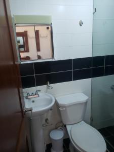 a bathroom with a toilet and a sink and a mirror at Recidencial job in Santiago de los Caballeros