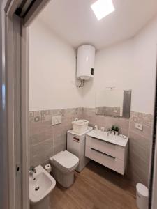 uma casa de banho com um WC, um lavatório e um espelho. em Movie Apartment em Beinette