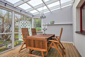 a conservatory with a wooden table and chairs on a deck at very comfortable room in a unique villa in Gävle