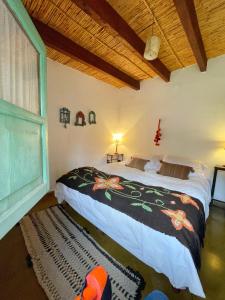 a bedroom with a bed and a large window at Los Arcabuceros Posada Boutique in Tilcara