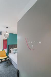 Deluxe Studio Apartments في ديربي: غرفه فندقيه بسرير وكرسي