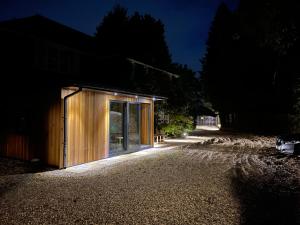 una pequeña casa de madera en un camino de grava por la noche en Da Vinci Guest House & Guest Parking en Crawley