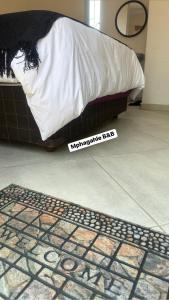 a bedroom with a bed and a sign on the floor at Mphagahle B&B in Mthenti