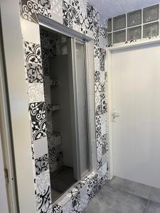 a mirror in a bathroom with black and white tiles at Your dream flat in Vohenstrauß