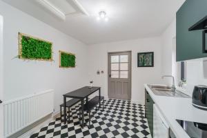 uma cozinha com piso em xadrez preto e branco em Deluxe Studio Apartments em Derby