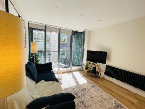 a living room with a couch and a flat screen tv at The Farringdon Flat in London