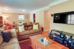 a living room with couches and a flat screen tv at Royal Oak Home 13 Mi to Downtown Detroit in Royal Oak