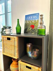 une étagère avec des vases et un livre sur elle dans l'établissement La barrière/hyper centre/calme, à Rodez