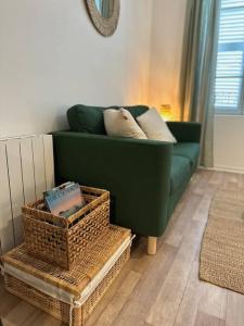 a green couch in a living room with baskets at La barrière/hyper centre/calme in Rodez