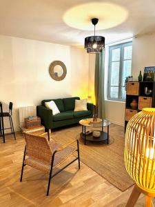 a living room with a green couch and a table at La barrière/hyper centre/calme in Rodez