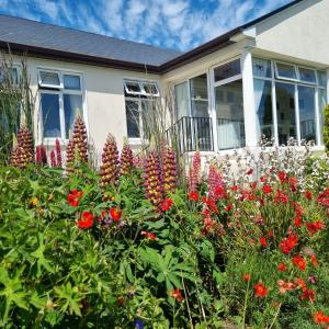 einen Blumengarten vor einem Haus in der Unterkunft Rowanville Lodge in Grange