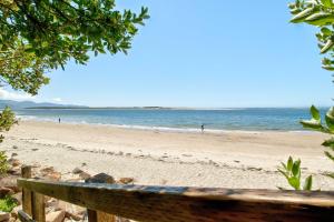 um banco numa praia com o oceano ao fundo em Terimore Lodging by the Sea em Tillamook