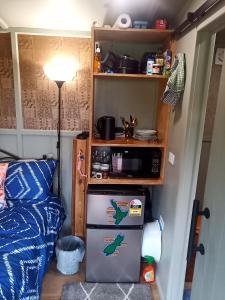 a small refrigerator in a room with a shelf at Bush Cabin Stunning views in Taumarunui