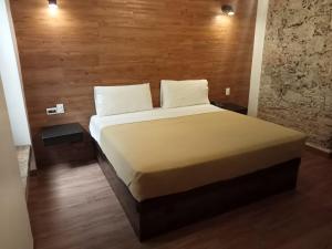 een groot bed in een kamer met een houten muur bij Hotel Sonno Plaza Allende in Mexico-Stad