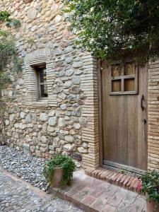 un edificio de piedra con una puerta de madera y una ventana en Can Carbó de Peralada en Peralada