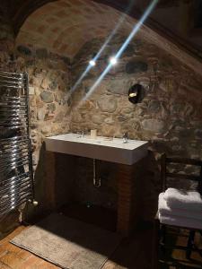 La salle de bains est pourvue d'un lavabo et d'un mur en pierre. dans l'établissement Can Carbó de Peralada, à Peralada