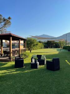 eine Terrasse mit Stühlen und einem Pavillon auf dem Rasen in der Unterkunft Mondello Holiday Home in Mondello