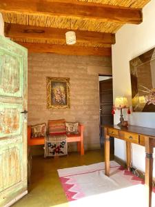 a room with a table and a bench in a room at Los Arcabuceros Posada Boutique in Tilcara