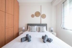 una camera da letto con un grande letto bianco con tre cuscini di Irodis at Koukaki By Greece Apartment ad Atene