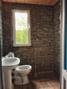 a bathroom with a sink and a toilet and a window at Kari in Kharagauli