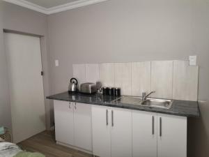 a kitchen with a sink and a counter top at Izibusiso Guest room in East London